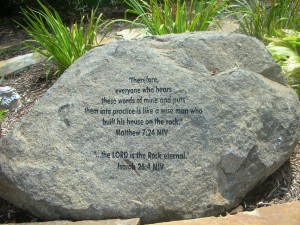 Hand picked boulder engraved with Bible passage in the rain garden